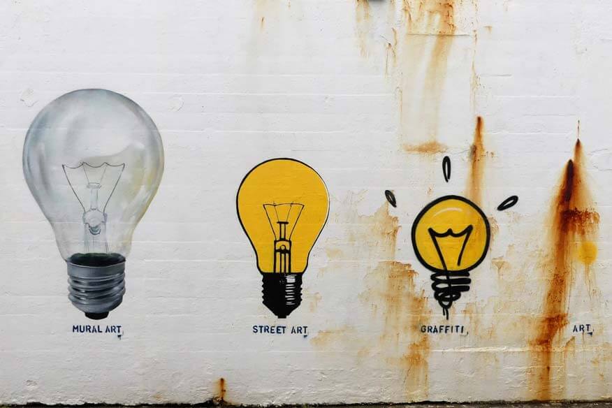 Vergleich zwischen Graffiti, Street Art, Mural Art und Urban Art anhand stilisierter Glühbirnen
