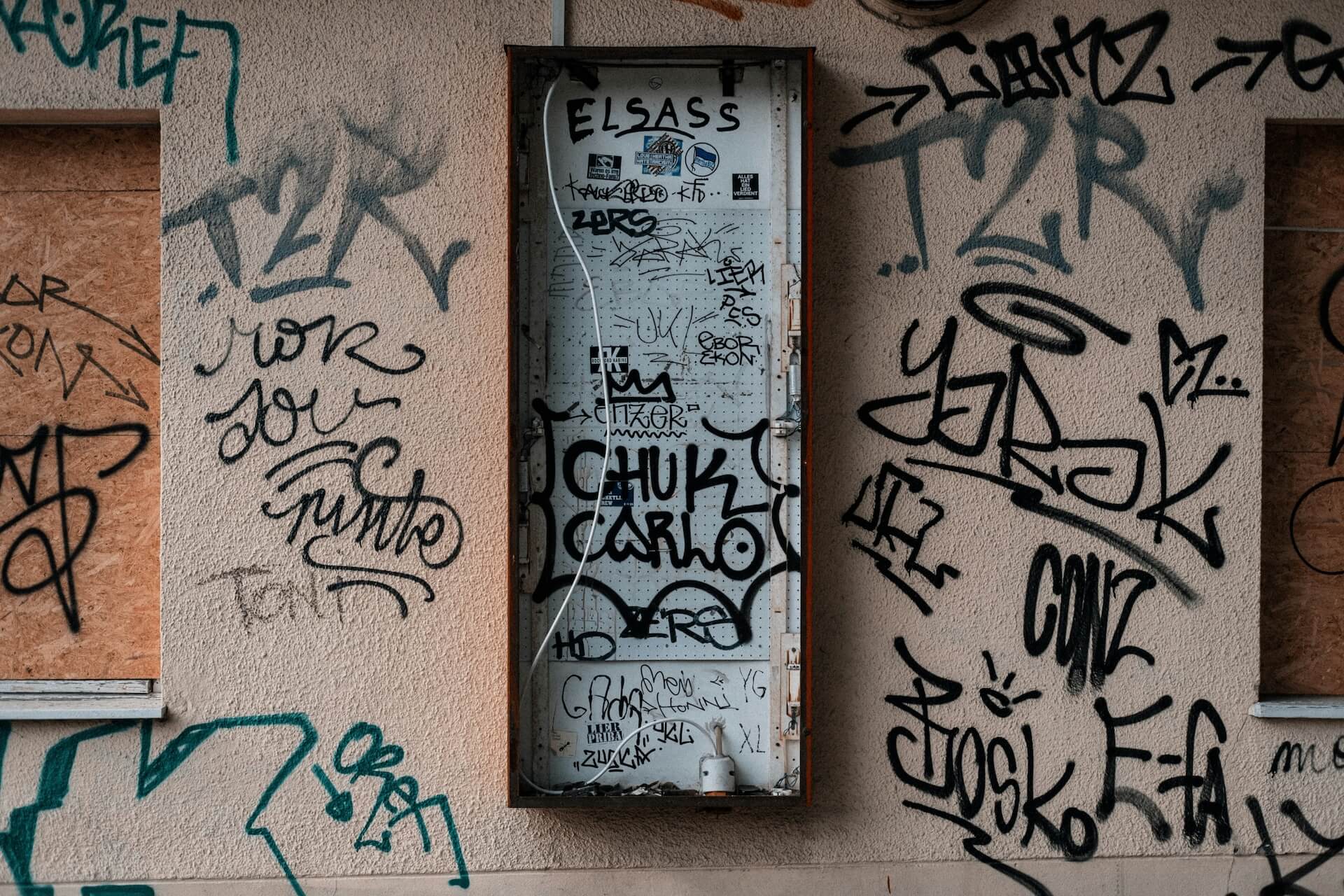 Wand mit Graffiti-Tags und Zahlen, die Postleitzahlen oder Vorwahlen symbolisieren – Ausdruck regionaler Zugehörigkeit.