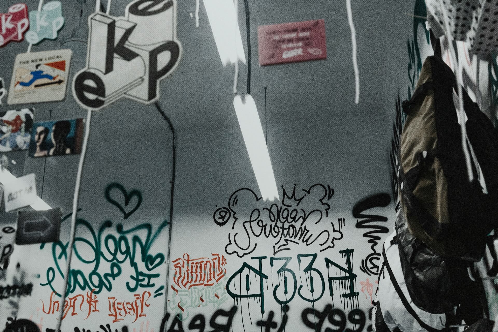 Innenraum mit authentischen Graffiti-Tags und Zahlencodes wie 1312 und 187 – Symbol für die Sprache der Graffiti-Kultur.